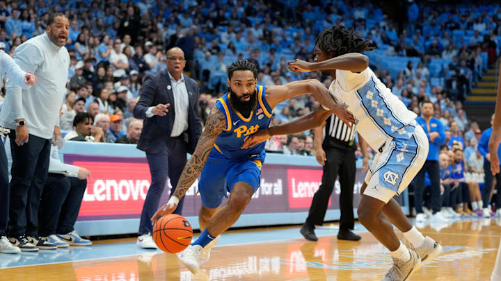 Feb 8, 2025; Chapel Hill, North Carolina, USA;  Pittsburgh Panthers guard Damian Dunn (1) dribbles as North Carolina Tar Heels guard Ian Jackson (11) defends in the first half at Dean E. Smith Center. Mandatory Credit: Bob Donnan-Imagn Images