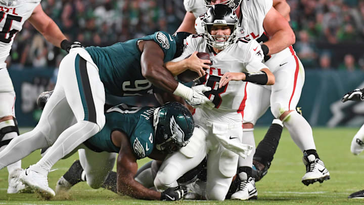 Sep 16, 2024; Philadelphia, Pennsylvania, USA; Atlanta Falcons quarterback Kirk Cousins (18) is tackled by Philadelphia Eagles defensive end Bryce Huff (0) and  defensive tackle Moro Ojomo (97) during the second quarter at Lincoln Financial Field. Mandatory Credit: Eric Hartline-Imagn Images