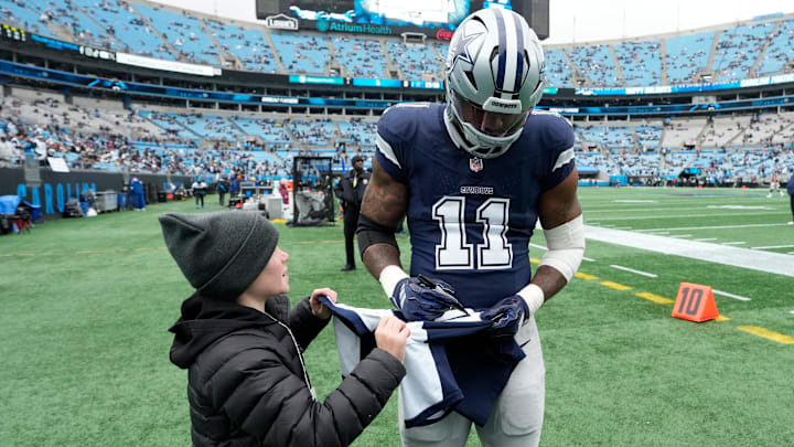 Dallas Cowboys linebacker Micah Parsons signs a jersey for a fan before the game at Bank of America Stadium. Dallas Cowboys linebacker Micah Parsons signs a jersey for a fan before the game at Bank of America Stadium.