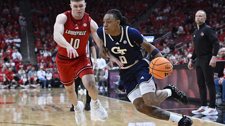 Feb 21, 2026; Louisville, Kentucky, USA;  Georgia Tech Yellow Jackets guard Akai Fleming (0) dribbles against Louisville Cardinals guard Isaac McKneely (10) during the first half at KFC Yum! Center. Mandatory Credit: Jamie Rhodes-Imagn Images
