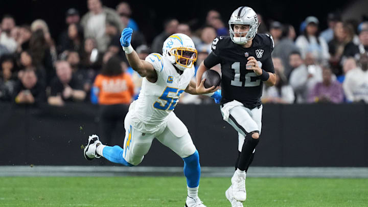 Las Vegas Raiders quarterback Aidan O'Connell carries the ball against Los Angeles Chargers linebacker Khalil Mack in the second half at Allegiant Stadium. 