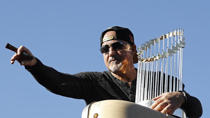 Washington, DC, USA; Washington Nationals general manager Mike Rizzo waves while holding the championship trophy during the Nationals' World Series championship parade on the National Mall.