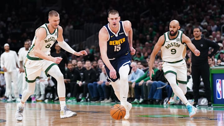 Jan 19, 2024; Boston, Massachusetts, USA; Denver Nuggets center Nikola Jokic (15) returns the ball against Boston Celtics center Kristaps Porzingis (8) and guard Derrick White (9) in the first quarter at TD Garden. Mandatory Credit: David Butler II-Imagn Images Jan 19, 2024; Boston, Massachusetts, USA; Denver Nuggets center Nikola Jokic (15) returns the ball against Boston Celtics center Kristaps Porzingis (8) and guard Derrick White (9) in the first quarter at TD Garden. Mandatory Credit: David Butler II-Imagn Images