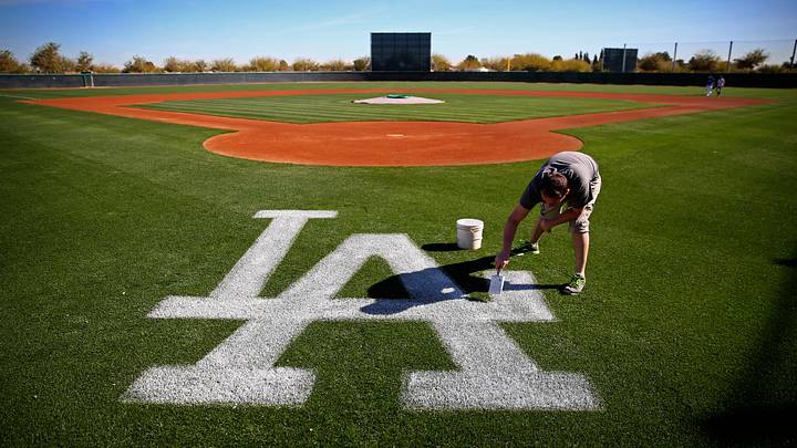 Feb 12, 2014; Glendale, AZ, USA; A groundskeeper paints the Los Angeles Dodgers logo onto a practice field during team workouts at Camelback Ranch. Mandatory Credit: Mark J. Rebilas-USA TODAY Sports Feb 12, 2014; Glendale, AZ, USA; A groundskeeper paints the Los Angeles Dodgers logo onto a practice field during team workouts at Camelback Ranch. Mandatory Credit: Mark J. Rebilas-USA TODAY Sports