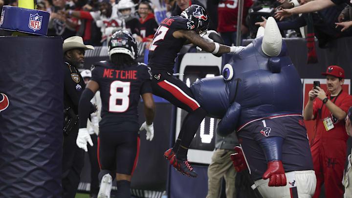 Jan 11, 2025; Houston, Texas, USA;  Houston Texans wide receiver Nico Collins (12) scores a touchdown against the Los Angeles Chargers in the second quarter in an AFC wild card game at NRG Stadium. Mandatory Credit: Thomas Shea-Imagn Images
