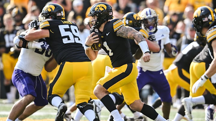 Oct 12, 2024; Iowa City, Iowa, USA; Iowa Hawkeyes quarterback Brendan Sullivan (1) runs the ball for a short gain during the fourth quarter against the Washington Huskies at Kinnick Stadium. Mandatory Credit: Jeffrey Becker-Imagn Images