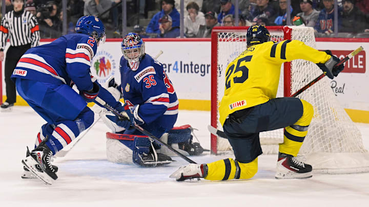 Dec 31, 2025; St. Paul, Minnesota, USA; Sweden forward Eddie Genborg (25) scores a power play goal on USA goalie Brady Knowling (35) as defensemen Luke Osburn (2) closes in during the second period in group play during the 2026 IIHF World Junior Championship at Grand Casino Arena. Mandatory Credit: Nick Wosika-Imagn Images