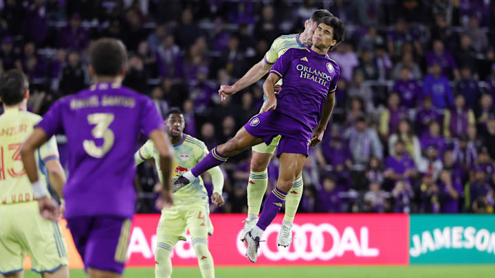 Nov 30, 2024; Orlando, Florida, USA; Orlando City forward Ramiro Enrique (7) battles for a header against New York Red Bulls defender Dylan Nealis (12) during the first half in the 2024 MLS Cup Eastern Conference Final match at Inter&Co Stadium. Mandatory Credit: Mike Watters-Imagn Images