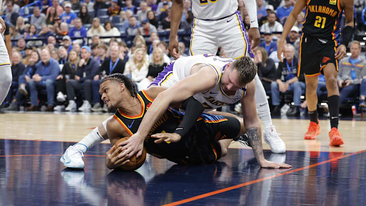 Apr 6, 2025; Oklahoma City, Oklahoma, USA; Oklahoma City Thunder forward Dillon Jones (3) and Los Angeles Lakers guard Luka Doncic (77) fight for a loose ball during the second half at Paycom Center. Mandatory Credit: Alonzo Adams-Imagn Images Apr 6, 2025; Oklahoma City, Oklahoma, USA; Oklahoma City Thunder forward Dillon Jones (3) and Los Angeles Lakers guard Luka Doncic (77) fight for a loose ball during the second half at Paycom Center. Mandatory Credit: Alonzo Adams-Imagn Images