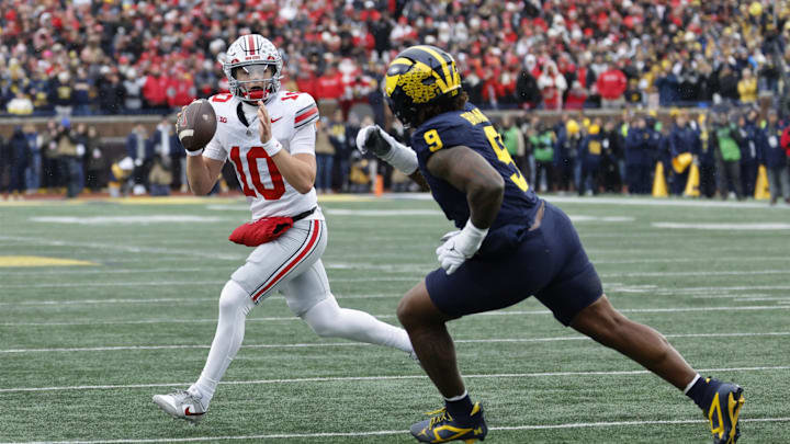 Nov 29, 2025; Ann Arbor, Michigan, USA; Ohio State Buckeyes quarterback Julian Sayin (10) runs the ball pressured by Michigan Wolverines defensive end Cameron Brandt (9) in the first half at Michigan Stadium. Mandatory Credit: Rick Osentoski-Imagn Images