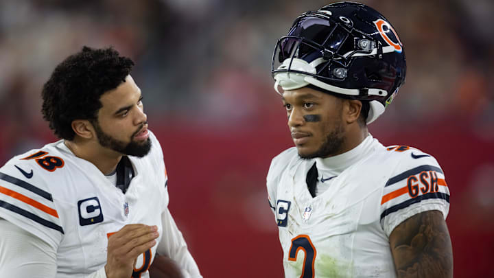 Chicago Bears quarterback Caleb Williams (18) talks with wide receiver DJ Moore (2) against the Arizona Cardinals at State Farm Stadium.