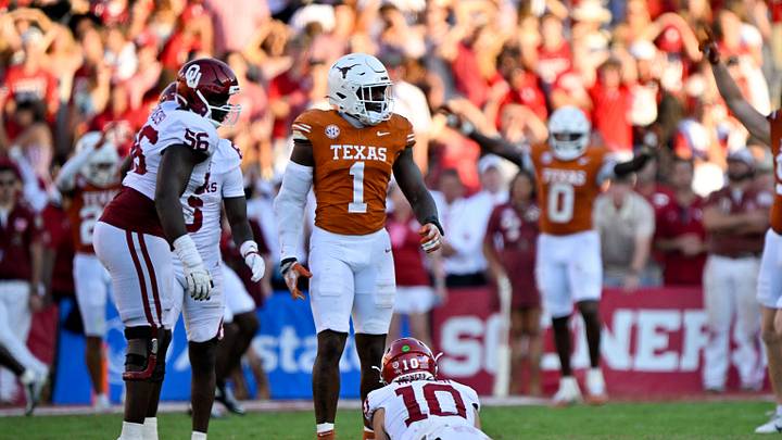 Oct 11, 2025; Dallas, Texas, USA; Texas Longhorns defensive end Colin Simmons (1) stands over Oklahoma Sooners quarterback John Mateer (10) after Mateer is sacked during the second half at the Cotton Bowl. Mandatory Credit: Jerome Miron-Imagn Images Oct 11, 2025; Dallas, Texas, USA; Texas Longhorns defensive end Colin Simmons (1) stands over Oklahoma Sooners quarterback John Mateer (10) after Mateer is sacked during the second half at the Cotton Bowl. Mandatory Credit: Jerome Miron-Imagn Images