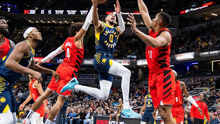 Nov 27, 2023; Indianapolis, Indiana, USA; Indiana Pacers guard Tyrese Haliburton (0) shoots the ball while Portland Trail Blazers guard Matisse Thybulle (4) and guard Malcolm Brogdon (11) defend in the second half at Gainbridge Fieldhouse. Mandatory Credit: Trevor Ruszkowski-USA TODAY Sports