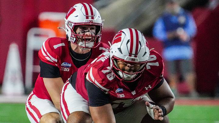 Wisconsin Badgers quarterback Colton Joseph (1) calls for the snap from Stylz Blackmon (76). 