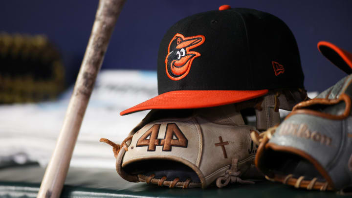 A detailed view of a Baltimore Orioles hat and glove in the dugout A detailed view of a Baltimore Orioles hat and glove in the dugout