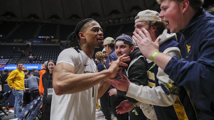 Jan 27, 2026; Morgantown, West Virginia, USA; West Virginia Mountaineers guard Jasper Floyd (1) celebrates with fans after defeating the Kansas State Wildcats at Hope Coliseum. Mandatory Credit: Ben Queen-Imagn Imagesa