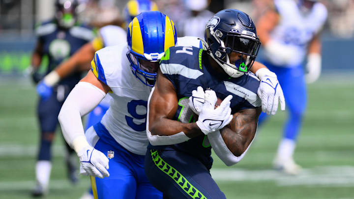 Sep 10, 2023; Seattle, Washington, USA; Seattle Seahawks wide receiver DK Metcalf (14) protects the ball from Los Angeles Rams linebacker Michael Hoecht (97) during the first half at Lumen Field. Mandatory Credit: Steven Bisig-Imagn Images