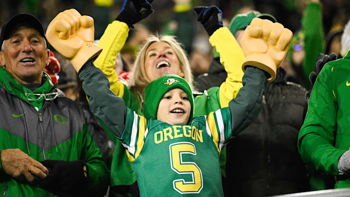 Dec 20, 2025; Eugene, OR, USA; An Oregon Ducks fan cheers during the fourth quarter against the James Madison Dukes at Autzen Stadium. Mandatory Credit: Troy Wayrynen-Imagn Images Dec 20, 2025; Eugene, OR, USA; An Oregon Ducks fan cheers during the fourth quarter against the James Madison Dukes at Autzen Stadium. Mandatory Credit: Troy Wayrynen-Imagn Images