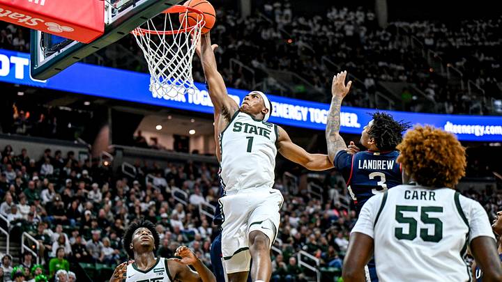 Michigan State’s Jeremy Fears Jr., center, dunks between UConn’s Na’jai Hines and Colben Landrew, right, during the first half on Tuesday, Oct. 20, 2026, at the Breslin Center in East Lansing.