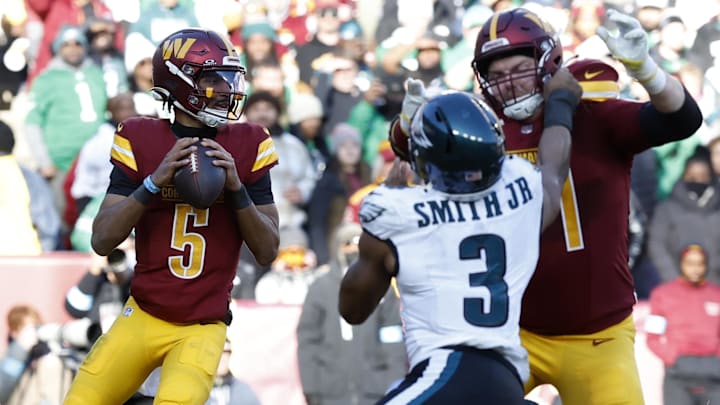 Washington Commanders quarterback Jayden Daniels (5) prepares to pass the ball as Philadelphia Eagles linebacker Nolan Smith Jr. (3) defends during the second quarterat Northwest Stadium.
