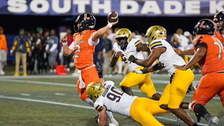 Lakeland Dreadnaughts quarterback Chad Williams (12) is pressured by St. Thomas Aquinas Raiders defensive end Trevor Sommers (90) during a 34-0 loss in the FHSAA Class 5A Football Championship on Thursday, December 12, 2024 in Miami, FL. Jeff Romance/Special to the USA Today Florida Network