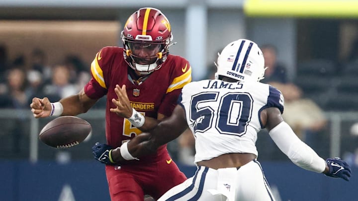 Washington Commanders quarterback Jayden Daniels fumbles the ball defended by Dallas Cowboys linebacker Shemar James.
