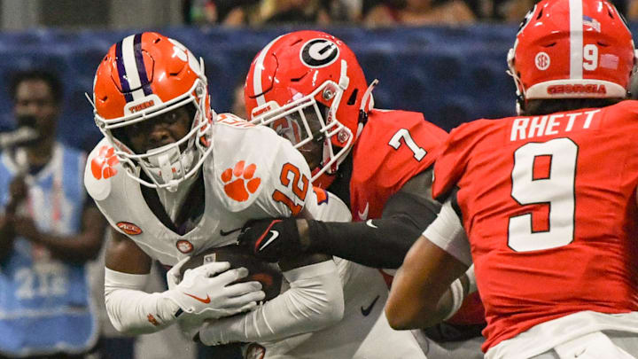 Aug 31, 2024; Atlanta, Georgia, USA; Clemson Tigers wide receiver Bryant Wesco Jr. (12) is tackled by Georgia Bulldogs defensive back Daniel Harris (7) after a catch during the fourth quarter of the 2024 Aflac Kickoff Game at Mercedes-Benz Stadium. 