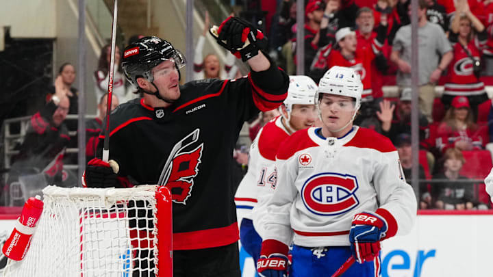Mar 28, 2025; Raleigh, North Carolina, USA;  Carolina Hurricanes right wing Andrei Svechnikov (37) scores an empty net goal past Montreal Canadiens right wing Cole Caufield (13) during the third period at Lenovo Center. Mandatory Credit: James Guillory-Imagn Images