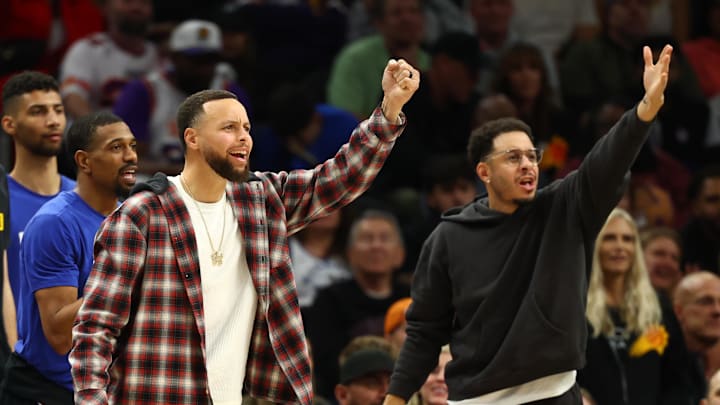 Feb 5, 2026; Phoenix, Arizona, USA; Golden State Warriors guard Stephen Curry (left) and brother Seth Curry react against the Phoenix Suns in the second half at Mortgage Matchup Center. Mandatory Credit: Mark J. Rebilas-Imagn Images