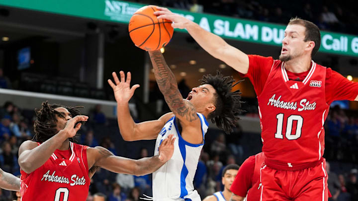 Memphis' PJ Haggerty (4) is blocked by Arkansas State's Avery Felts (10) as he goes for a layup during the game between Arkansas State University and the University of Memphis at FedExForum in Memphis, Tenn., on Sunday, December 8, 2024.