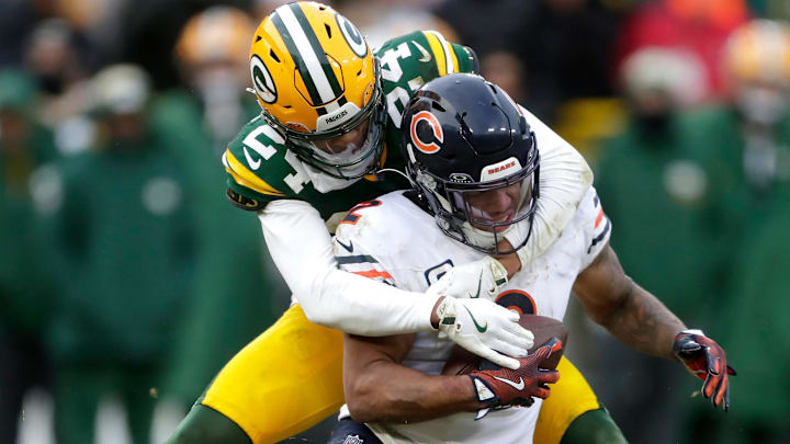Green Bay Packers cornerback Carrington Valentine (24) tackles Chicago Bears wide receiver DJ Moore (2) on Sunday, January 5, 2024 at Lambeau Field in Green Bay, Wis. The Bears defeated the Packers 24-22.