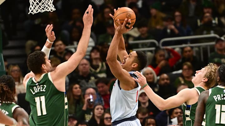 Dec 21, 2024; Milwaukee, Wisconsin, USA: Washington Wizards guard Malcolm Brogdon (15) shoots the ball against Milwaukee Bucks center Brook Lopez (11) in the second quarter at Fiserv Forum. Mandatory Credit: Benny Sieu-Imagn Images