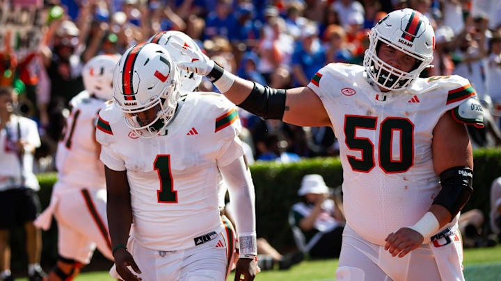 Miami Hurricanes quarterback Cam Ward (1) is congratulated by Miami Hurricanes center Zach Carpenter (50) after scoring a touchdown during the season opener at Ben Hill Griffin Stadium in Gainesville, FL on Saturday, August 31, 2024 against the University of Miami Hurricanes in the first half. Miami lead 24-10 at the half. [Doug Engle/Gainesville Sun]