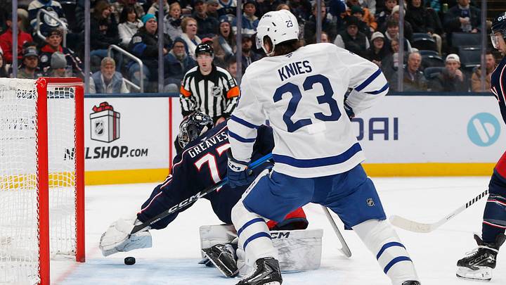 Nov 26, 2025; Columbus, Ohio, USA; Columbus Blue Jackets goalie Jet Greaves (73) reaches to cover a loose puck in the crease as Toronto Maple Leafs left wing Matthew Knies (23) looks for a rebound during the first period at Nationwide Arena. Mandatory Credit: Russell LaBounty-Imagn Images