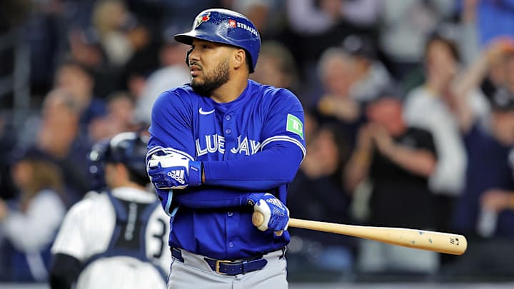 Toronto Blue Jays slugger Anthony Santander with his arms crossed and bat pointed out in a blue jersey and gray pants. Toronto Blue Jays slugger Anthony Santander with his arms crossed and bat pointed out in a blue jersey and gray pants.