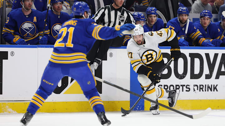 Apr 21, 2026; Buffalo, New York, USA; Boston Bruins center Mark Kastelic (47) skates with the puck as Buffalo Sabres defenseman Conor Timmins (21) looks to defend during the first period in game two of the first round of the 2026 Stanley Cup Playoffs at KeyBank Center. Mandatory Credit: Timothy T. Ludwig-Imagn Images