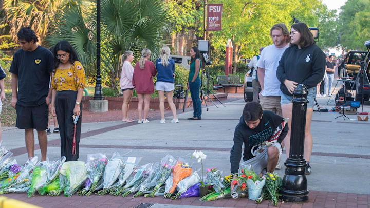 People place flowers at a makeshift memorial near the scene of a shooting on the Florida State University campus in Tallahassee, Florida on Thursday, April 17, 2025.