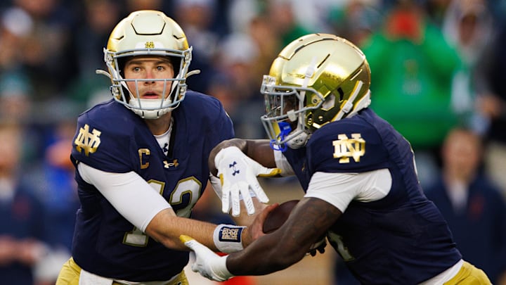Notre Dame quarterback Riley Leonard (13) hands the ball off to running back Jeremiyah Love (4) during a NCAA college football game against Virginia at Notre Dame Stadium on Saturday, Nov. 16, 2024, in South Bend.