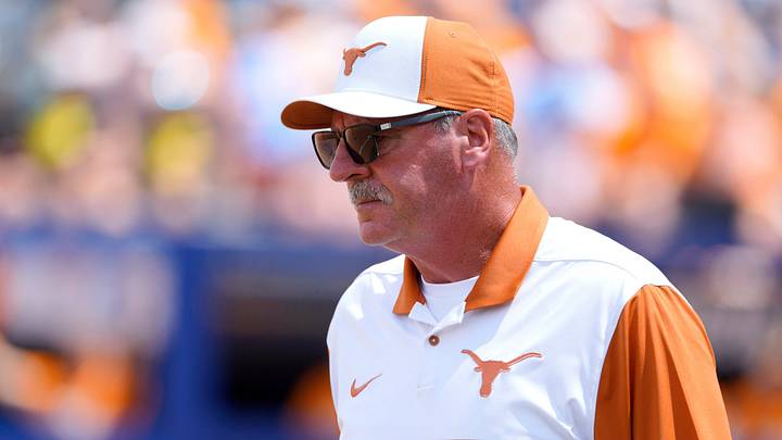 Texas Longhorns head coach Mike White walks on the field during a Women's College World Series softball game between the Tennessee Volunteers and the Texas Longhorns. Texas Longhorns head coach Mike White walks on the field during a Women's College World Series softball game between the Tennessee Volunteers and the Texas Longhorns.