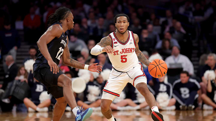 Mar 13, 2025; New York, NY, USA; St. John's basketball guard Deivon Smith (5) brings the ball up court against Butler Bulldogs guard Kolby King (12) during the second half at Madison Square Garden.
