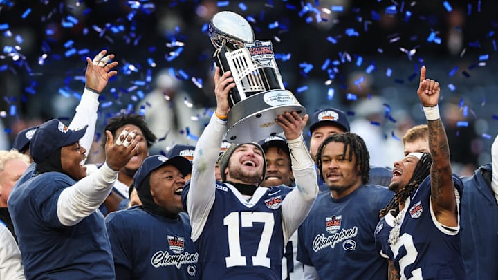Penn State Nittany Lions quarterback Ethan Grunkemeyer (17) and teammates celebrate with the George M. Steinbrenner Trophy after defeating the Clemson Tigers in the 2025 Pinstripe Bowl at Yankee Stadium. 