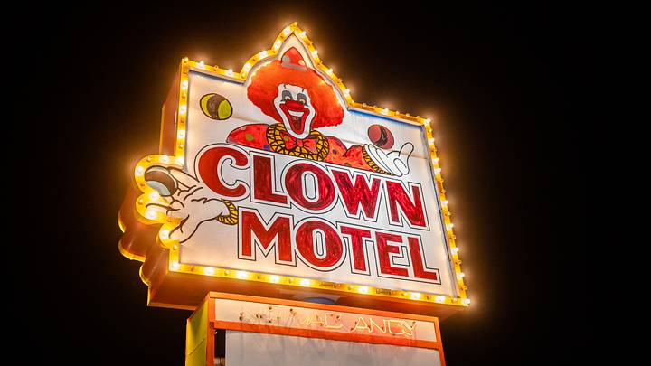 Sign for the Clown Motel illuminated against night sky Sign for the Clown Motel illuminated against night sky