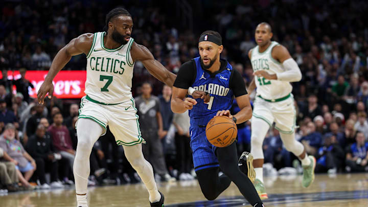 Dec 23, 2024; Orlando, Florida, USA; Orlando Magic guard Jalen Suggs (4) drives to the basket past Boston Celtics guard Jaylen Brown (7) in the third quarter at Kia Center. Mandatory Credit: Nathan Ray Seebeck-Imagn Images