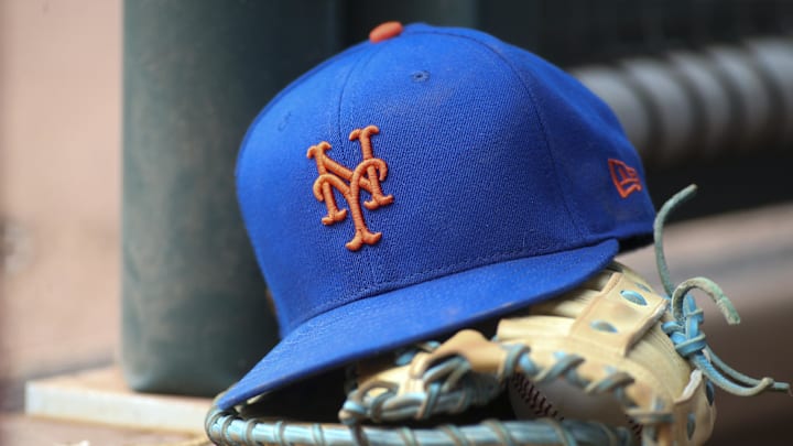 Jul 13, 2022; Atlanta, Georgia, USA; A detailed view of a New York Mets hat and glove in the dugout against the Atlanta Braves in the eighth inning at Truist Park. Mandatory Credit: Brett Davis-Imagn Images