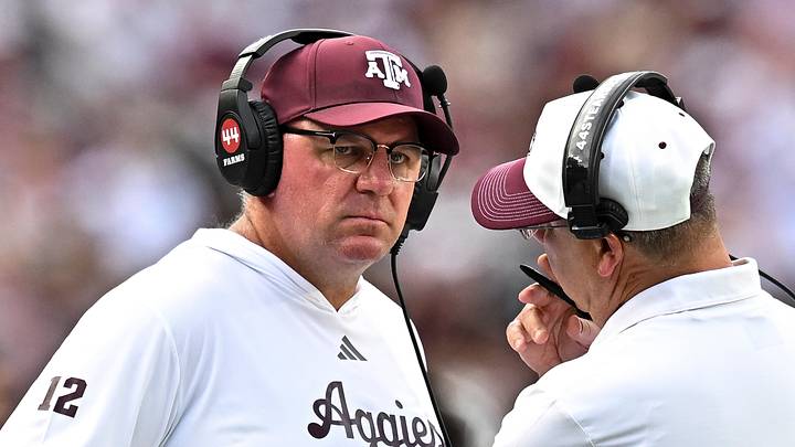 Sep 19, 2026; College Station, Texas, USA;  Texas A&M Aggies head coach Mike Elko speaks with a member of his coaching staff during a time-out in the fourth quarter against the Kentucky Wildcats at Kyle Field. Mandatory Credit: Maria Lysaker-Imagn Images