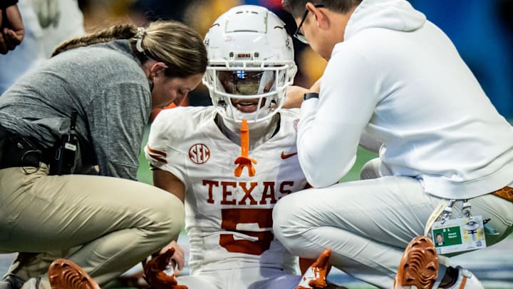 Texas Longhorns defensive back Malik Muhammad (5) discusses an injury with trainers before heading to the locker room in the third quarter as the Texas Longhorns play the Arizona State Sun Devils in the Peach Bowl College Football Playoff quarterfinal at Mercedes-Benz Stadium in Atlanta, Georgia, Jan. 1, 2025.