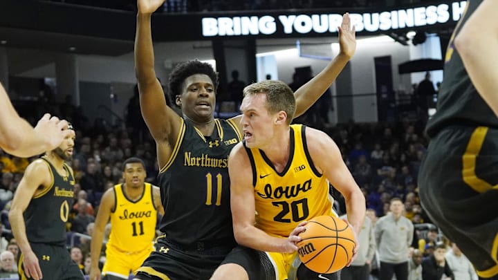 Northwestern Wildcats guard Jordan Clayton (11) defends Iowa Hawkeyes forward Payton Sandfort (20)  during the first half at Welsh-Ryan Arena.