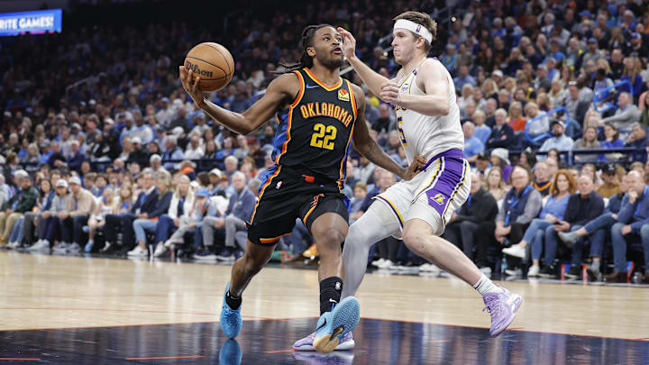 Apr 6, 2025; Oklahoma City, Oklahoma, USA; Oklahoma City Thunder guard Cason Wallace (22) drives to the basket against Los Angeles Lakers guard Austin Reaves (15) during the second half at Paycom Center.