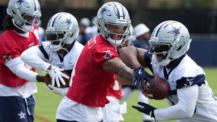Dallas Cowboys quarterback Dak Prescott hands the ball off to running back Javonte Williams during training camp.