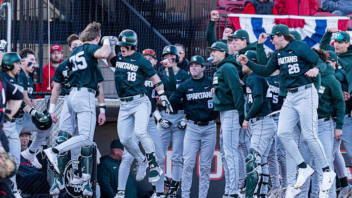 The Michigan State team celebrates the go-ahead run as the Spartans defeated the Louisville Cardinals 4–3. 